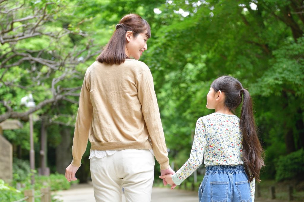 手を繋いで歩く母娘の様子