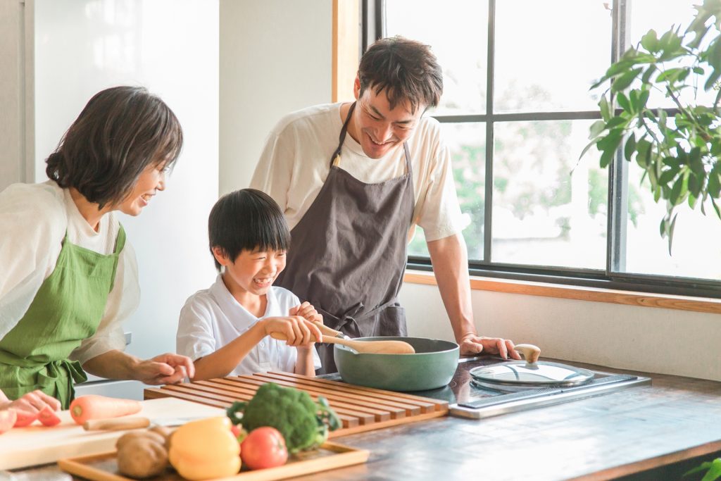 キッチンで子供と料理する家族の様子