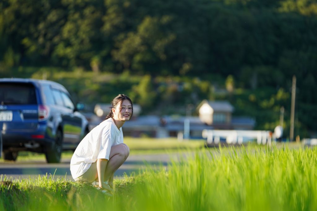 畑の畦道で座る農業女子2の様子