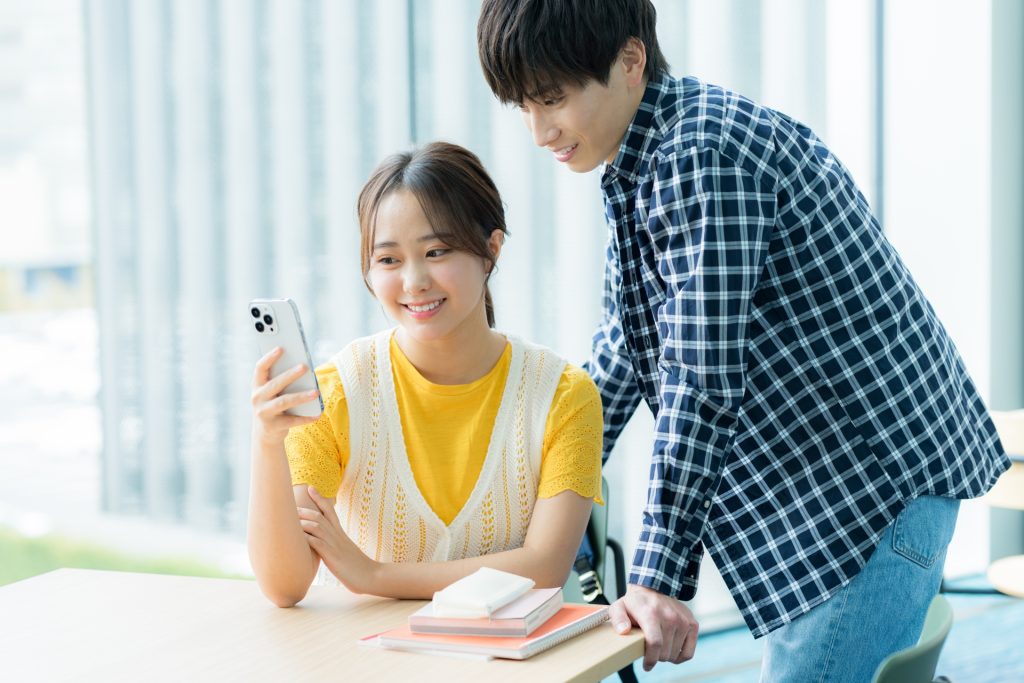 スマホを見ながら話す学生たちの様子