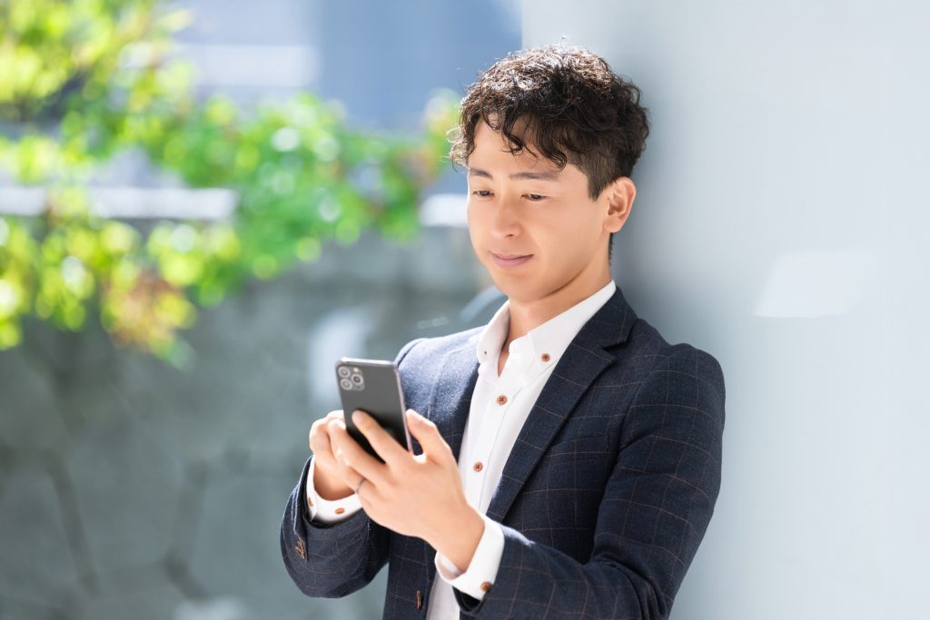 スマホを使う男性ビジネスマンの様子