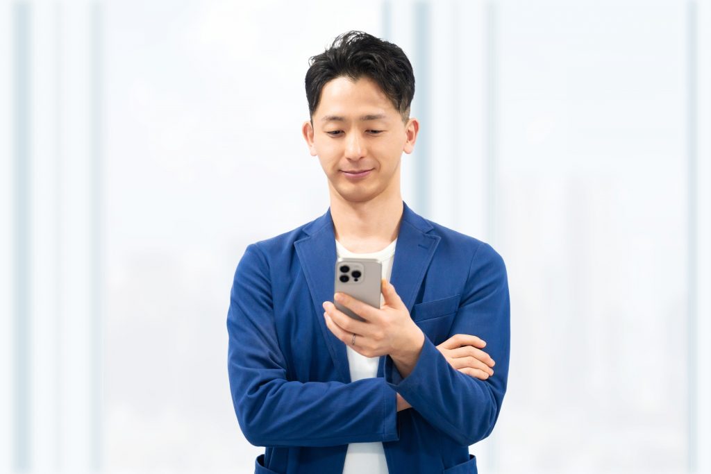 スマホを使う男性ビジネスマンの様子